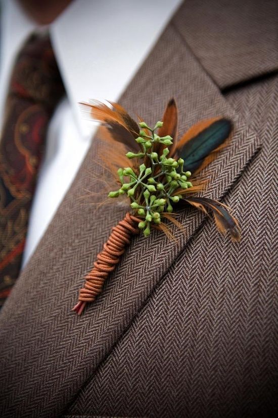a boho fall wedding boutonniere with bright feathers, berries and bright twine is a lovely and bold accessory for a fall wedding