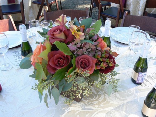 a simple and elegant fall flower centerpiece of dark roses, bright blooms and eucalyptus is timeless