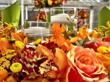 a bright and colorful fall flower centerpiece with a couple of floating candles is very bold and statement-like
