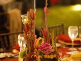 a bright fall wedding centerpiece with greenery and lush colorful flowers, pumpkins and candles