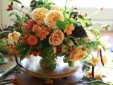 a fine art fall wedding centerpiece or orange, red and peachy blooms, greenery and foliage is lovely for fall