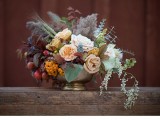 a chic fall wedding centerpiece in a vintage bowl, with blush and peachy blooms, fruit, berries, greenery and dried foliage