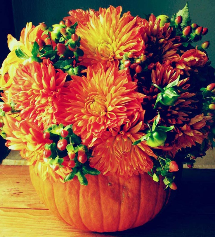 A fall pumpkin with bold blooms and berries is a lovely and simple fall rustic wedding centerpiece
