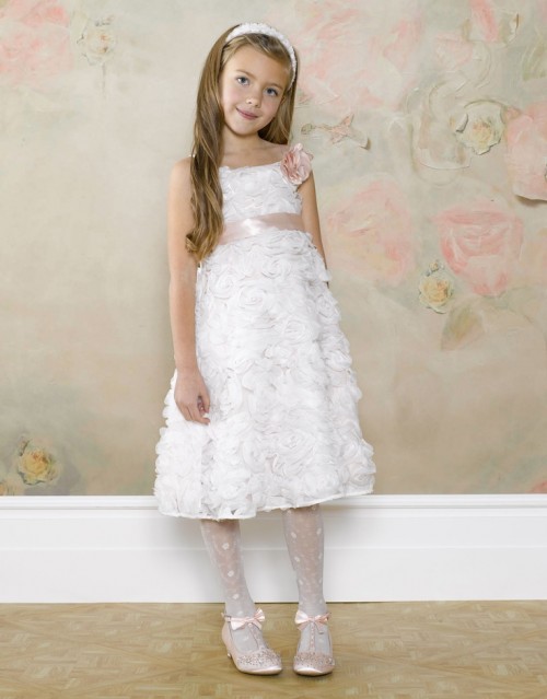 a white floral A-line flower girl dress with a pink sash, tights, embellished shoes and a pretty headpiece for a little princess