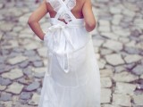 a relaxed white A-line flower girl maxi dress with ruffles and a bow on the back is a lovely idea for a summer wedding