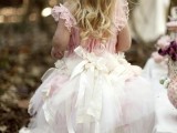 a pink and white midi A-line flower girl dress with a full skirt and lots of bows is a pretty and chic idea