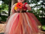 a strapless red, brown, rust and white tulle flower girl dress with a sash and bold blooms decorating the bodice for a fall wedding