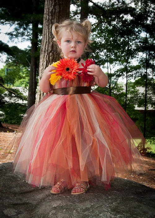 a strapless red, brown, rust and white tulle flower girl dress with a sash and bold blooms decorating the bodice for a fall wedding
