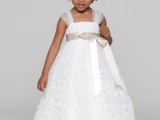 a white A-line flower girl dress with sheer cap sleeves, a sash and a floral skirt is a bold and cool solution