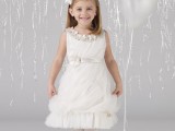a white layered flower girl dress with a floral neckline and a sash plus a floral headpiece for a beautiful girlish look