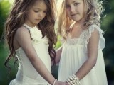 relaxed white flower girl dresses with lace, fabric flowers, ruffles are cool for a vintage or boho wedding