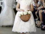 a white lace midi dress with short sleeves, a high neckline, a pink sash and white tights and flats for a classic flower girl look