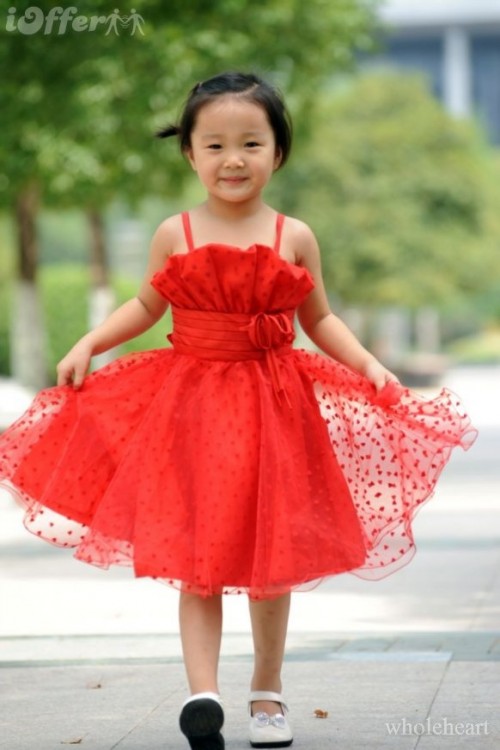 a red polka dot flower girl dress with a ruffle bodice and a layered skirt, spaghetti straps for a bold touch of color