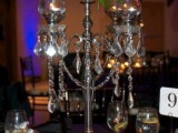 a refined Halloween wedding centepiece of a black candelabra with bold blooms on top and some crystals
