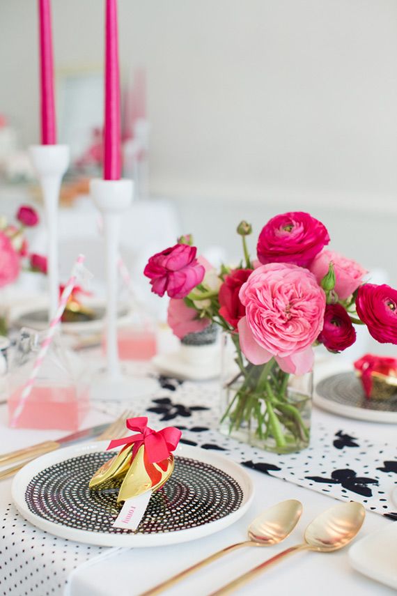 A modern bright Valentine's Day wedding tablescape done in black, white and fuchsia and light pink plus touches of gold