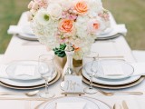 an elegant Valentine’s Day wedding tablescape with chic white linens, blush blooms, peachy touches and gold rimmer plates and chargers