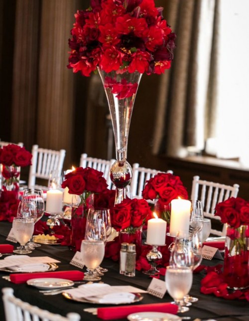 a bold black, white and red Valentine's wedding table with black runners, red napkins, petals and blooms, neutral candles and crystal glasses
