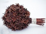 a stylish winter wedding bouquet of pinecones only and a chic ribbon wrap is non-typical and very cool