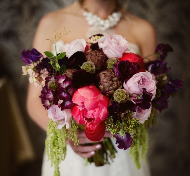 A colorful and sumptuous wedding bouquet in purple, pink and red plus greenery will add colro to your wedding look