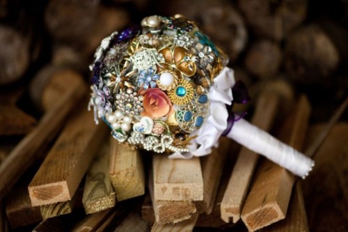 a colorful brooch wedding bouquet with a white ribbon wrap is a cool alternative to a usual one