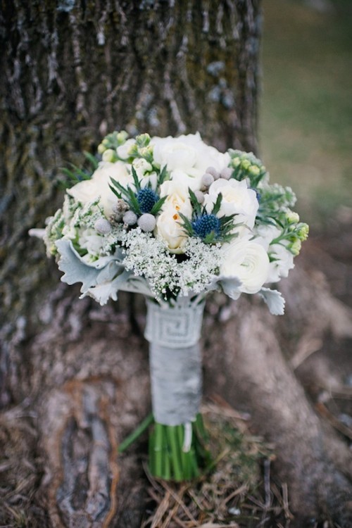 a beautiful white and blue wedding bouquet with berries and thistles plus a grey wrap
