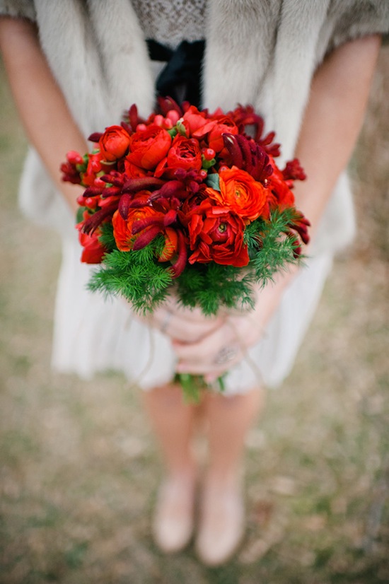 a red winter wedding bouquet with evergreens is a bold holiday wedding idea