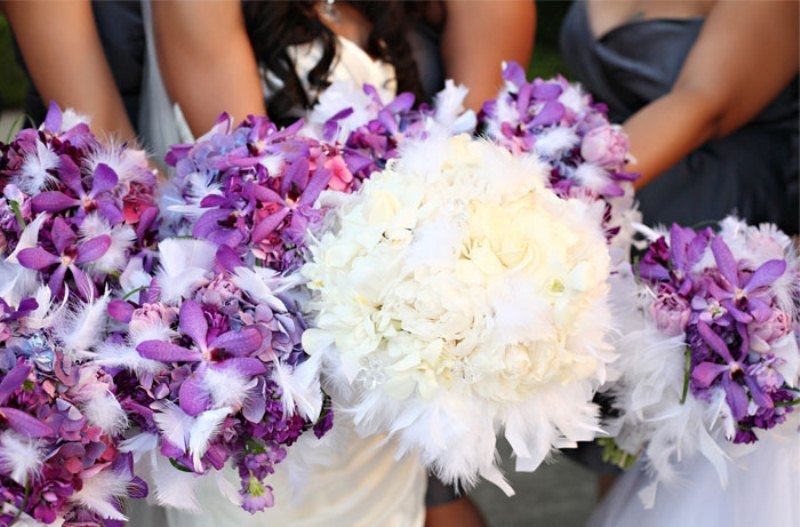 a white winter wedding bouquet of blooms and feathers is a cool idea for a soft and cool winter look