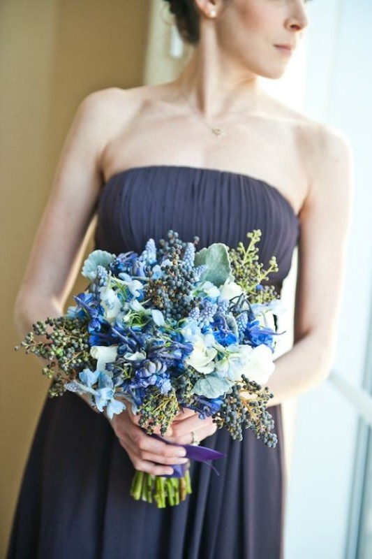 a bold winter wedding bouquet done in blues and neutrals, with foliage plus berries