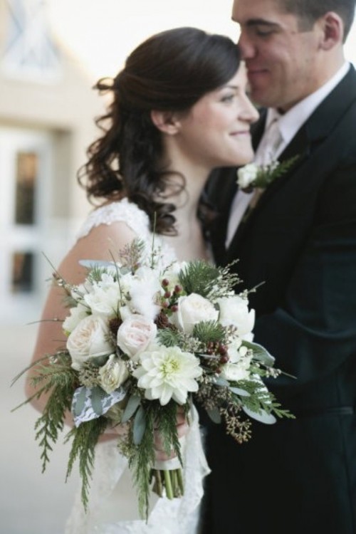 a cchic winter wedding bouquet with white and blush blooms, greenery and twigs is a stylish option