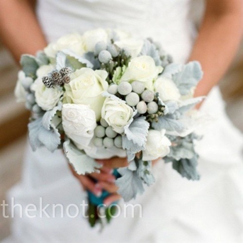 a pale winter wedding bouquet of foliage, blooms and berries looks frozen and very cold