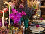 a super colorful tablecloth, bright blooms and vases, striped textiles, gold rim glasses