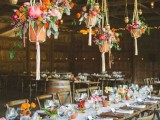 potted blooms and greenery plus hanging planters with colorful flowers over the table make it bright and boho