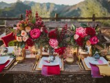 a lush and colorful tablescape with bright florals, textiles, gilded touches and candle lanterns