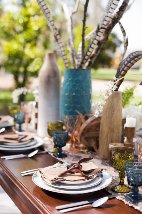 vases with feathers, colored glasses, candles and printed plates for a simple boho tablescape