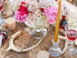 a faux fur tablecloth, antlers, gold chargers, candles, bright florals and colored glasses