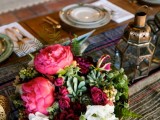 a folksy table runner, a bright floral centerpiece, Moroccan lanterns, printed plates
