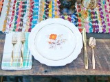 a colorful yarn table runner, bright napkins, colored glasses and bright blooms plus gold cutlery