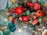 a super bright floral centerpiece with greenery, succulents, berries and brigth blooms for a summer boho wedding