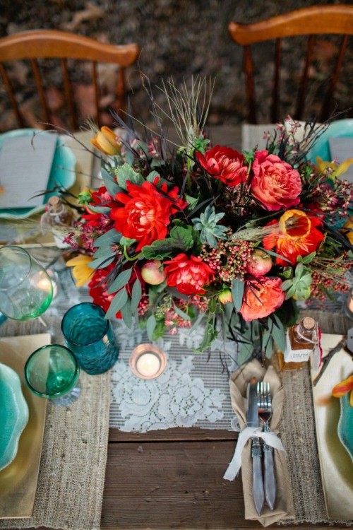 a super bright floral centerpiece with greenery, succulents, berries and brigth blooms for a summer boho wedding