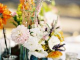 a silver tray with multiple vases and bright and neutral blooms and greenery for a simple boho centerpiece