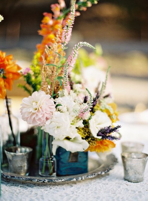a silver tray with multiple vases and bright and neutral blooms and greenery for a simple boho centerpiece
