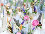 colorful blooms and feathers with table numbers in metallic vases for a summer boho wedding