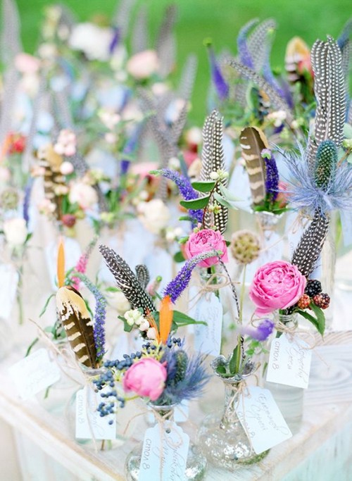 colorful blooms and feathers with table numbers in metallic vases for a summer boho wedding