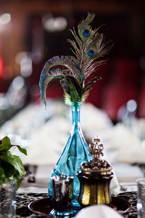 a turquoise bottle with peacock feathers is a bright idea for a Moroccan boho wedding