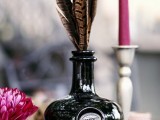 a black bottle with a feather arrangement is a stylish and laconic boho wedding centerpiece