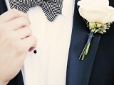 a black tux accented with a black and white geometric bow tie and neutral blooms for a refined and chic look
