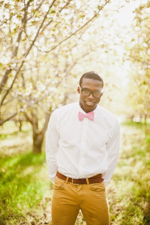 a stylish spring or summer groom's look with mustard pants, a white shirt, a pink printed bow tie and glasses