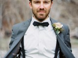 a grey suit, a black bow tie and suspenders plus a delicate floral boutonniere for a stylish summer or fall look