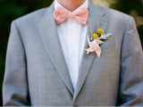 a dove grey suit, a white shirt, a printed peachy bow tie and a billy ball boutonniere for a spring or summer look