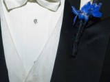 a morning suit with a white waistcoat and a matching bow tie and a white and blue floral boutonniere for an elegant touch
